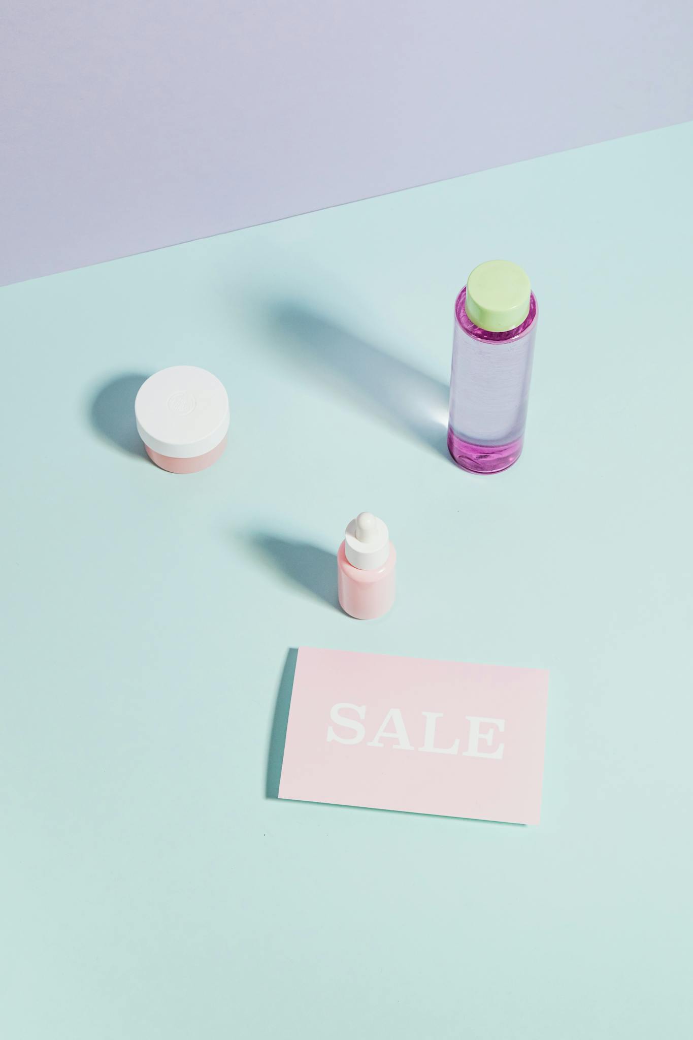 Flat lay of beauty products with sale card, perfect for promotions.